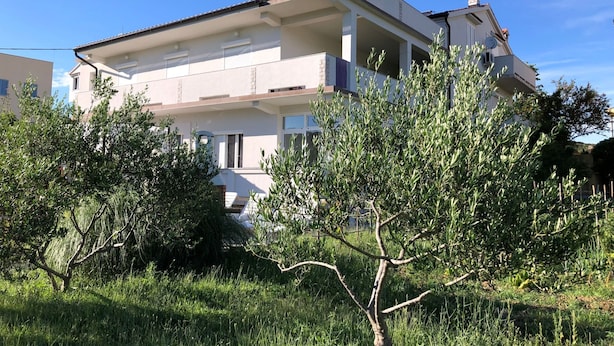A two-story residential building with a flat roof, white exterior walls, and a balcony on the upper floor. - The Blue Line Ferienwohnung mit Balkon by Interhome (Rab/Kampor)