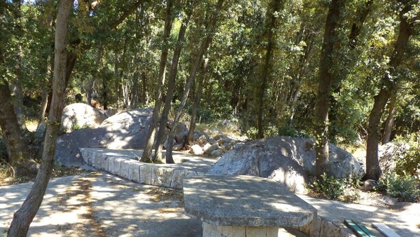 A stone bench in a wooded area with trees and rocks. - "Waldhaus" in der Nähe des Strandes by Interhome (Rab/Kampor)