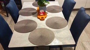A dining table with six woven placemats, a potted plant, and a decorative item on the center. - "Waldhaus" in der Nähe des Strandes by Interhome (Rab/Kampor)