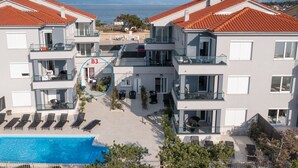 Un hôtel moderne doté d’une piscine sur le toit, de nombreux balcons et offrant une vue sur la mer.