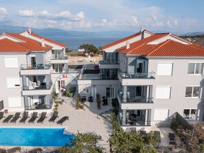 A modern hotel with a rooftop pool, multiple balconies, and a view of the sea. - Apartment Punta Silo by Interhome (Krk/Šilo)