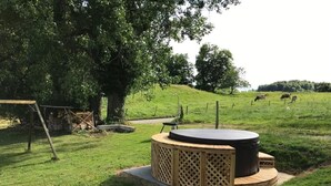 A circular wooden structure with a lattice design, surrounded by a grassy area with trees and a fence in the background. - "Ferme d' Alma" by Interhome (Seleute)