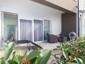 A balcony with a sun lounger, two wicker chairs, and a grill. - Wohnung Vita Mare mit Pool - Agentur TA Leut by Interhome (Privlaka)