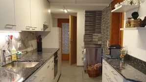 Een moderne keuken met witte kasten, granieten aanrechtbladen en roestvrijstalen apparatuur.