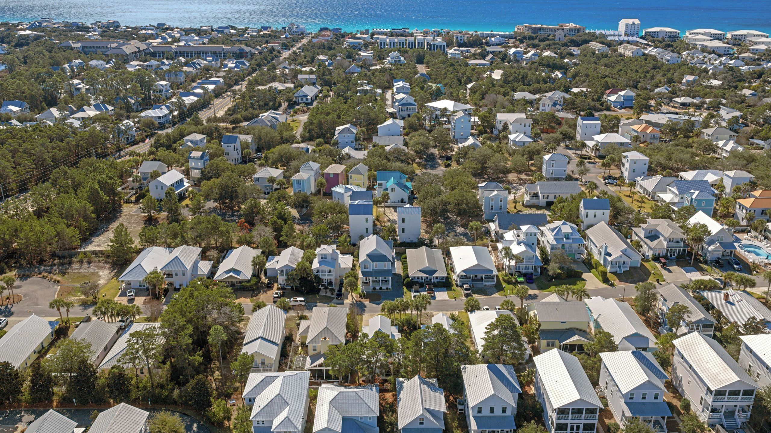 A residential area with houses, some with attached garages, and a clear view of the ocean.
