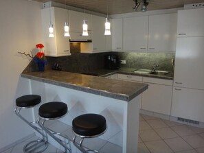 Een koelkast, een microgolfoven, een oven, kookgerei, borden en bestek