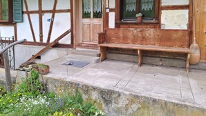 A wooden bench outside a building with a window and a door. - Stöckli EG by Interhome (Bowil)