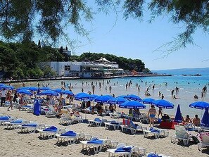 A beach with numerous blue umbrellas and white lounge chairs. - Dalmatinisches Haus in der Altstadt von Split by Interhome (Dragovode)