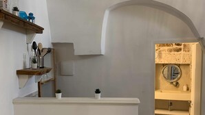A bathroom with a white vanity, a mirror, and a clock on the wall. - Biancostuni81, Le Piccole Case Bianche (Ostuni)