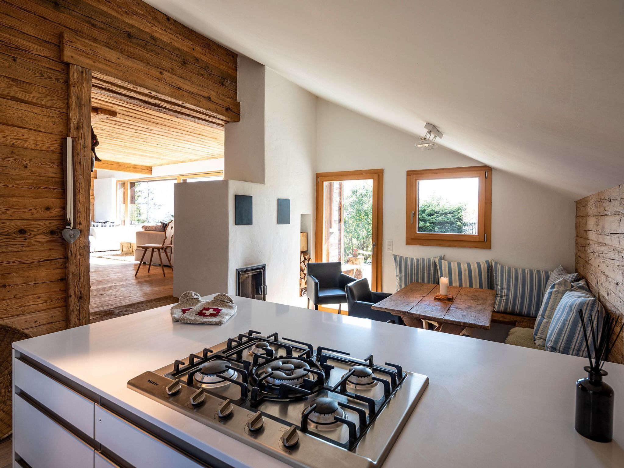 Une cuisine moderne dotée d’une cuisinière à gaz, de touches de bois et offrant une vue sur l’espace de vie.