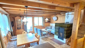 Ein gemütliches Blockhaus-Interieur mit Essbereich, Sofa und Kamin.