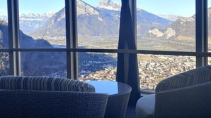 Ein Zimmer mit großem Fenster und Blick auf die Berge.