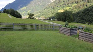 A grassy field with a wooden fence and a mountain backdrop. - "Ferienwohnung ""Spel Rein"" Cumpadials" by Interhome (Cumpadials)