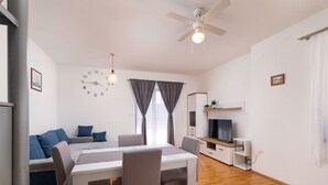 A modern living room with a dining table, sofa, and TV stand. - Ceković 2 by Interhome (Krk/Šilo)