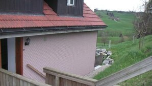 A house with a red roof, a wooden staircase, and a view of a green landscape. - Lamahof Tschäppel by Interhome (Huttwil)