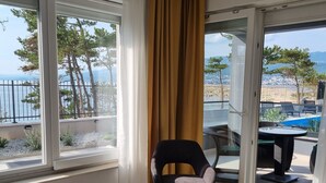 A room with a large window overlooking a pool and a scenic view. - Apartment Punta Silo by Interhome (Krk/Šilo)