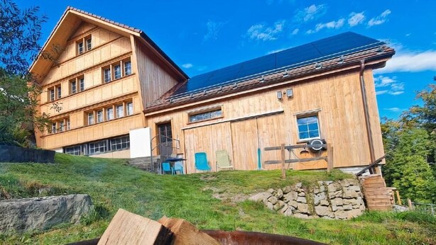 Un bâtiment en bois doté d’un toit en pente et de nombreuses fenêtres.