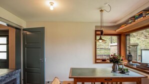 Un coin repas chaleureux avec une table en bois, un banc et une suspension décorative.