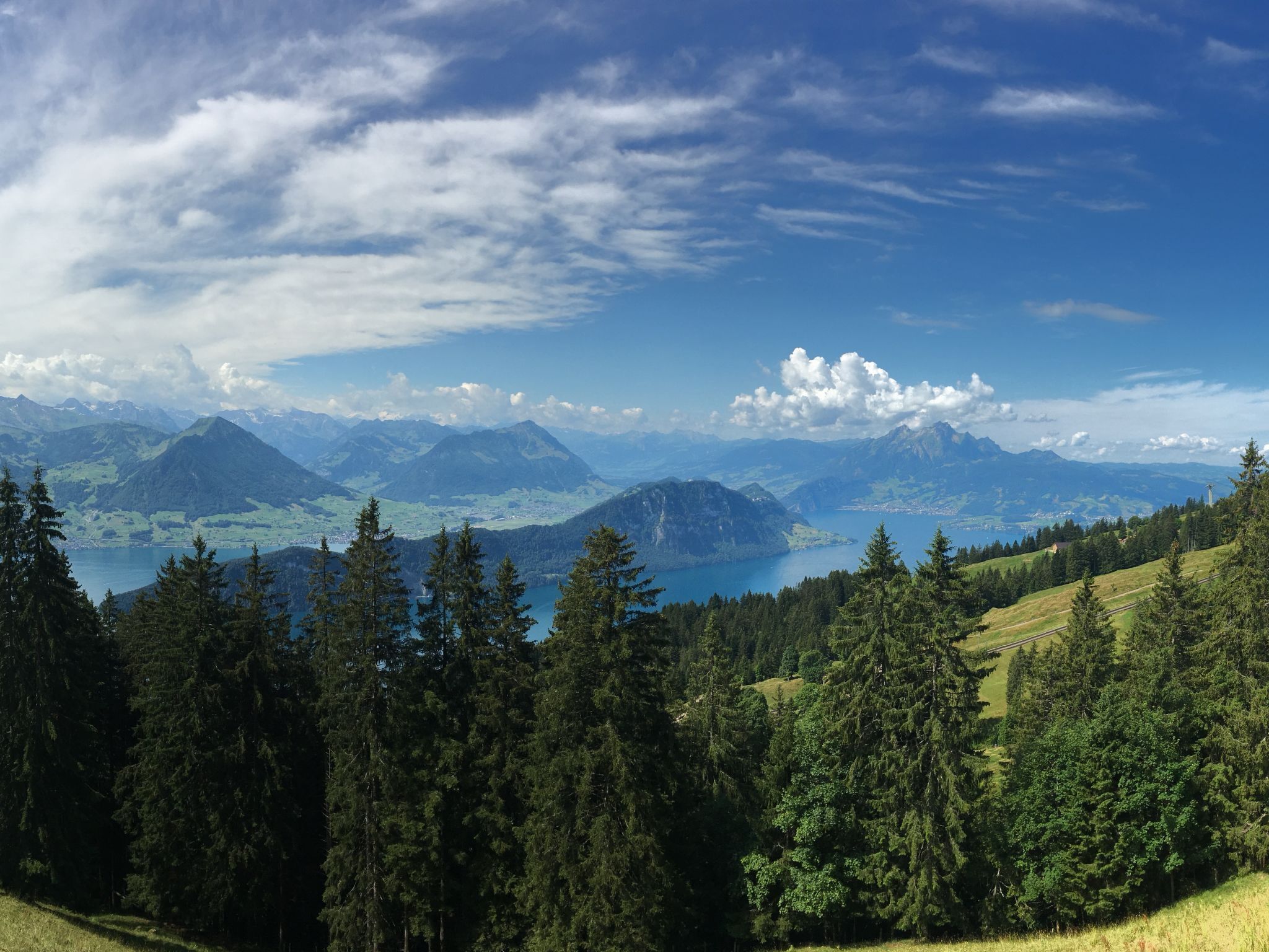 A mountainous landscape with dense forests and a lake.