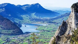 A mountainous landscape with a lake, a town, and a prominent cliff. - Fruehalp by Interhome (Unterägeri)