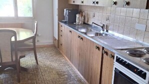 Une cuisine avec des meubles de rangement en bois, un pare-feu en carrelage, un évier et une cuisinière.
