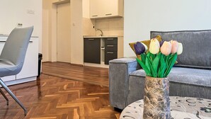 A modern hotel lobby with a seating area, a kitchenette, and a decorative vase with flowers. - Apartment Meri 2 by Interhome (Losinj / Mali Losinj)