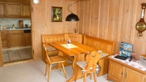 A wooden interior with a dining table, chairs, a bench, a clock, and a small cabinet. - FeWo Südhang by Interhome (Rüschegg Heubach)