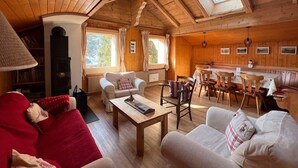 Ein gemütliches Holzhütten-Interieur mit Wohnbereich, Essbereich und Kamin.