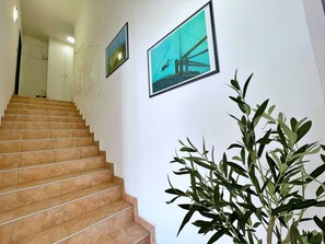 Eine Treppe führt zu einem Raum mit einem Bett und einem Nachttisch.
