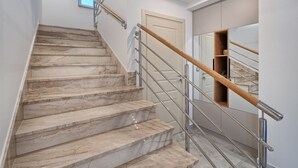 Una escalera de mármol con barandas de metal que conduce a una puerta.