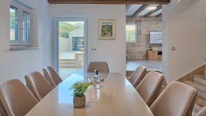 Un comedor moderno con una mesa larga, sillas de cuero y una planta en maceta.