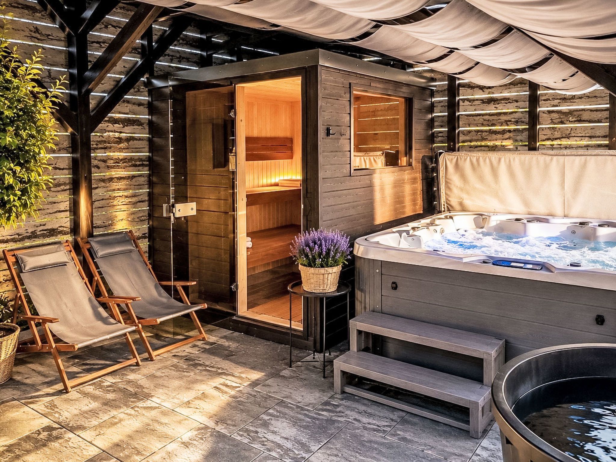 A spa area with a hot tub, wooden seating, and a sauna.