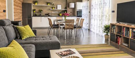 A modern living room with a sofa, coffee table, and a flat-screen TV.