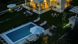 Uma casa moderna com piscina, área de estar externa e interior bem iluminado.