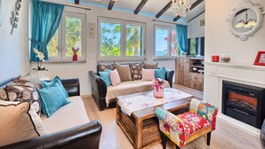 A cozy living room with a sofa, a wooden coffee table, and a fireplace. - Villa Antea by Interhome (Kaštel Sućurac)