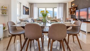 A modern dining area with a glass table, brown chairs, and a vase of yellow flowers. - in Dugopolje mit Privatem Pool by Interhome (Dugopolje)