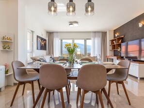 A modern dining area with a glass table, brown chairs, and a vase of yellow flowers. - in Dugopolje mit Privatem Pool by Interhome (Dugopolje)