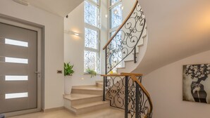 A modern interior with a curved staircase, a large window, and a door. - in Dugopolje mit Privatem Pool by Interhome (Dugopolje)
