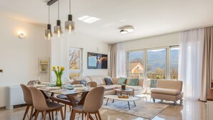 A modern living room with a dining area, large windows, and a view of the outdoors. - in Dugopolje mit Privatem Pool by Interhome (Dugopolje)