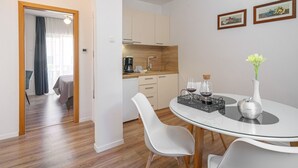 Moderni hotellihuone, jossa on ruokailutila, keittiö ja oleskelualue.
