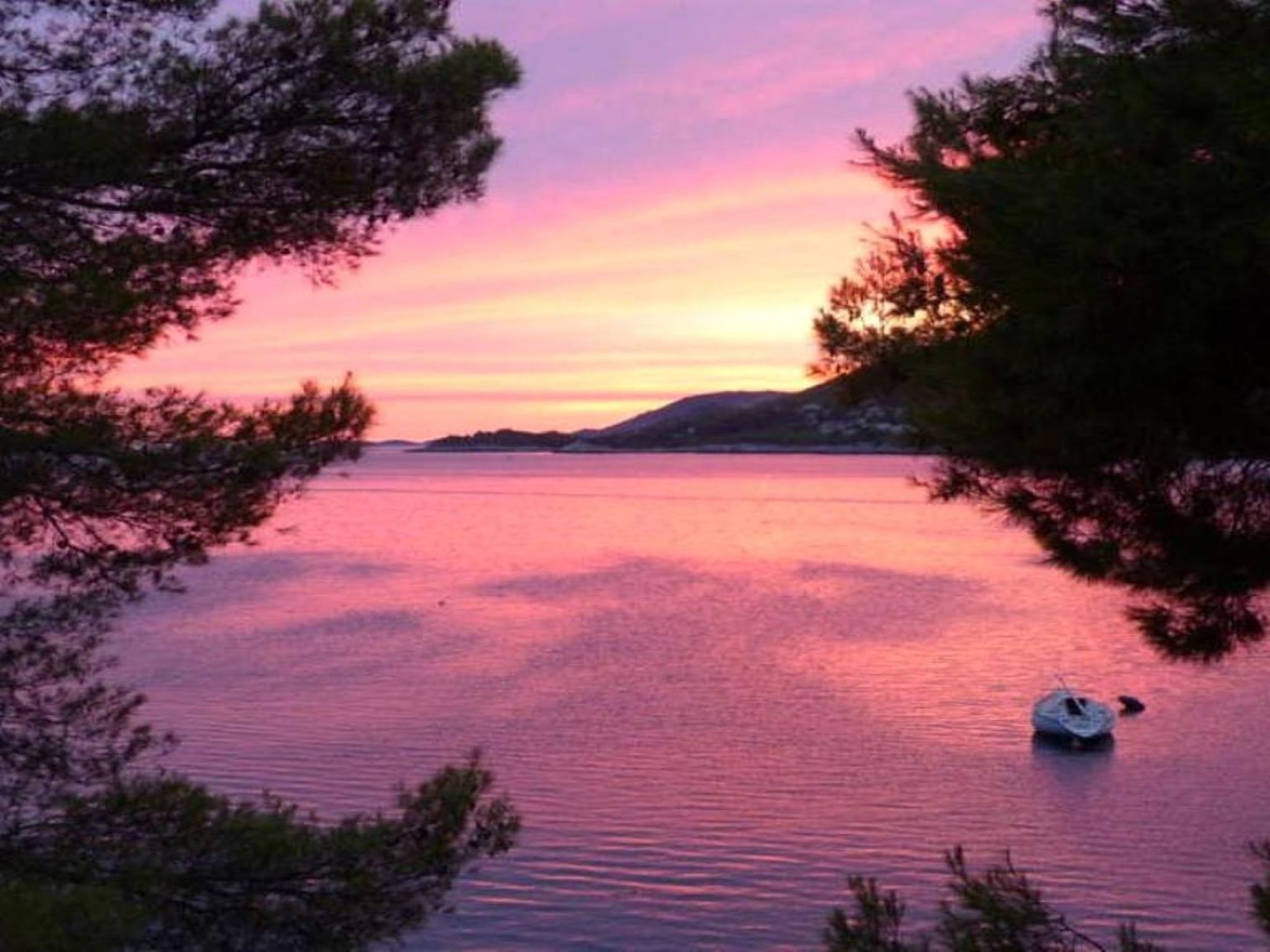 Een rustig meer met een boot bij zonsondergang.