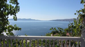 Un balcon avec vue sur la mer et les montagnes.