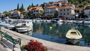 A marina with boats docked, a bench, and buildings in the background. - Kleines Steinhaus in einem ruhigen Ort auf der Insel Solta by Interhome (Gornje Selo)