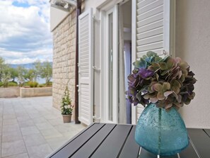 Une table avec un vase de fleurs sur un balcon.