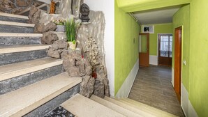 Una escalera con escalones de piedra y una pared verde.