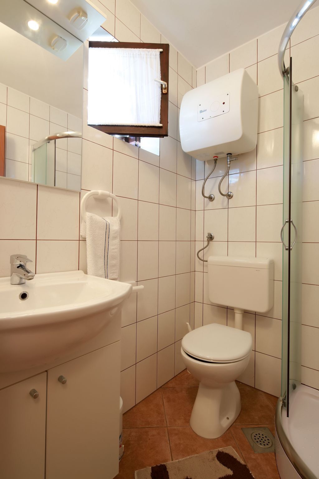 A bathroom with a sink, toilet, and shower.