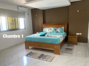 Ein Schlafzimmer mit einem hölzernen Bett, einem Fenster und einem Nachttisch.