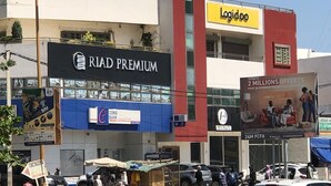 A building with a 'RIAD PREMIUM' sign, a 'Logido' sign, and a '2 MILLIONS OFFERS' advertisement. - Sweet Urban Teranga: Very well located apartment. Near the corniche, the center (Dakar)