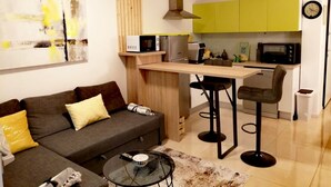 A compact living space with a sofa, a coffee table, a kitchen area with a microwave, a stove, and a sink. - für 5 Personen ca. 68 m² in Šilo, Adriaküste Kroatien (Kroatische Inseln) by Interhome (Krk/Šilo)
