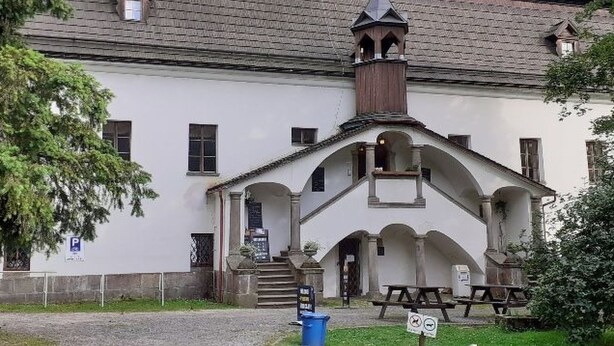 Un bâtiment blanc doté d’un toit à forte pente et d’un clocher.
